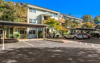 A parking lot with cars and apartment buildings in the background.