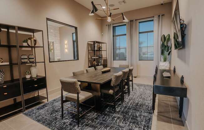 Resident conference room with large tv for displays, conference style table and shelving with décor.