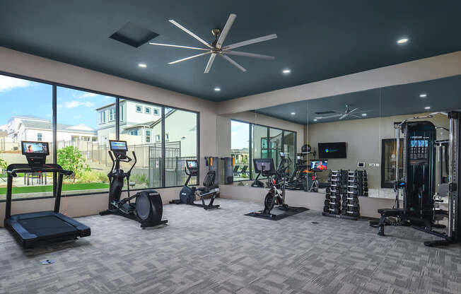 A spacious gym with a variety of equipment including treadmills, elliptical machines, and weight racks.