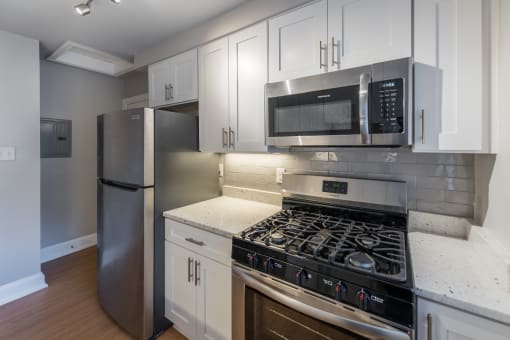 The Cary renovated kitchen with white cabinets, stainless steel appliances and a microwave