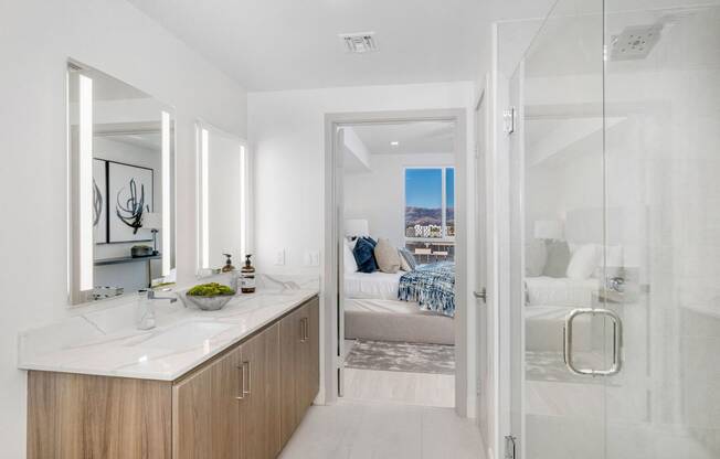 a bathroom with a shower and a sink and a bedroom