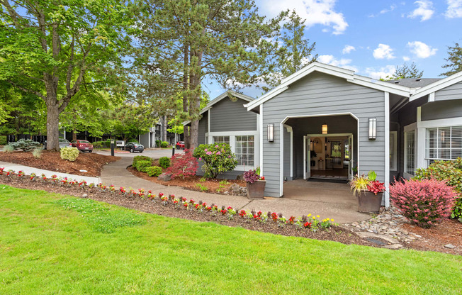 A house with a grey roof and a garden in front.