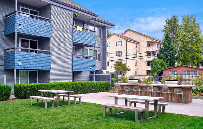 a picnic area with tables and chairs in front of an apartment building  at 3030 Lake City, Washington