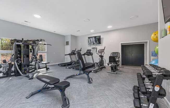 a gym with exercise machines and a television