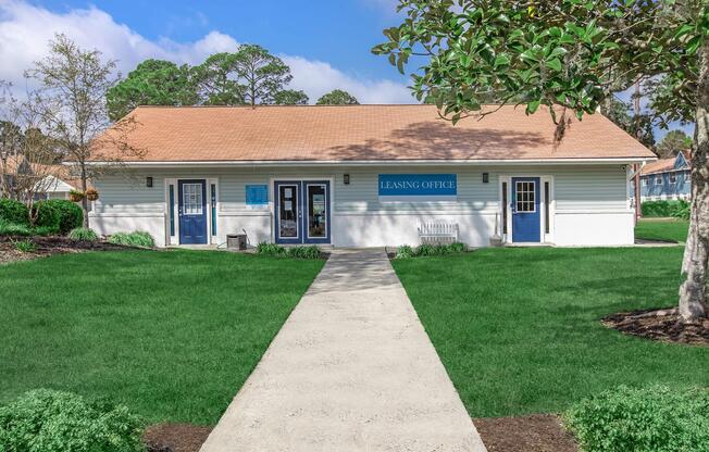a house with a lawn in front of a brick building