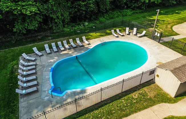 an aerial view of a resort style pool with lounge chairs and a hot tub