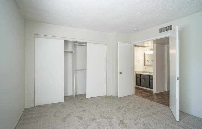 Carpeted bedroom with french doors at Treehouse Apartments in Albuquerque, New Mexico
