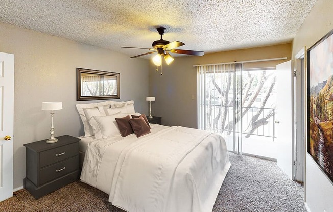 A bedroom with a bed, nightstand, and a ceiling fan.