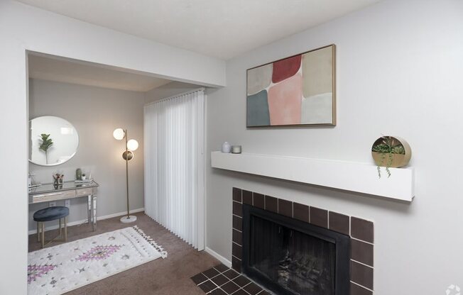 a living room with a fireplace and a desk