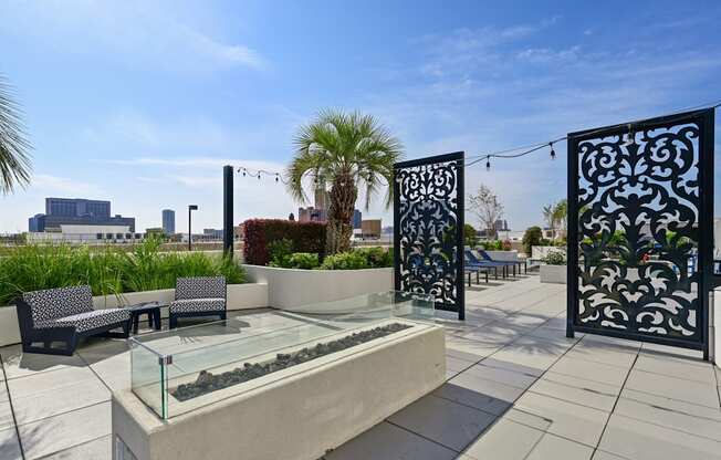 Rooftop patio with palm trees and a firepit at Dominion Post Oak apartments in Houston, TX