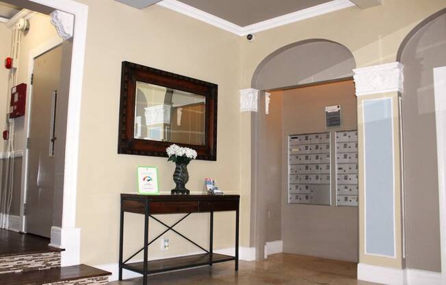 Pasadena Brookmore apartments lobby with tenant mailboxes and tall wall arches with decorative carved white trim.