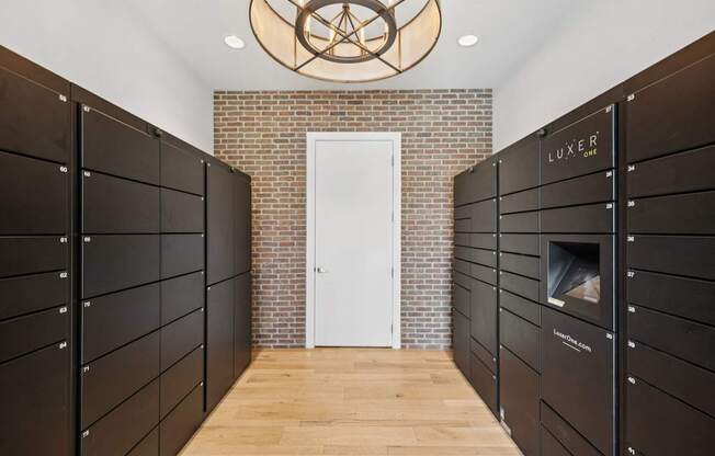 A hallway with a white door and a brick wall with a light fixture above it.