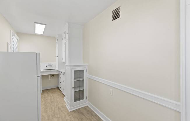 Side View of Kitchen with Small Built-In White Cabinet Area and a Refrigerator at Malloy Apartment Homes in Seattle, WA