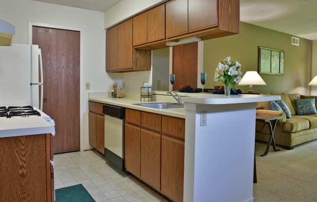 a kitchen with wooden cabinets and a white counter top at Beacon Hill and Great Oaks Apartments, Illinois, 61109