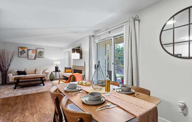 A dining room with a wooden table set for two.
