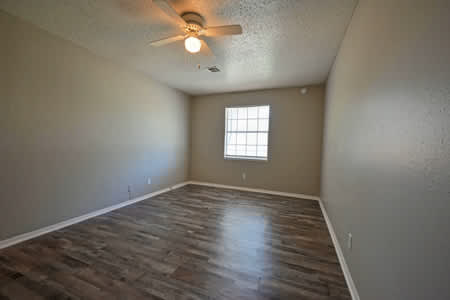 A room with a ceiling fan and a window.