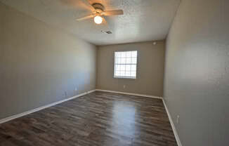 A room with a ceiling fan and a window.