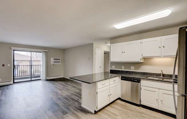 an empty kitchen with white cabinets and stainless steel appliances