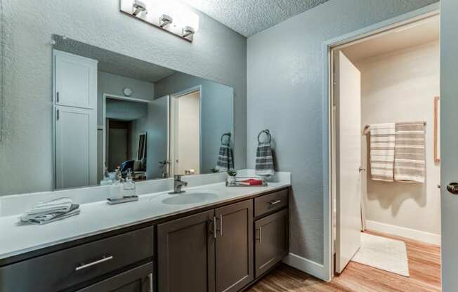 the master bathroom has a large mirror and a double sink at Aspire Upland Apartments, California, 91786