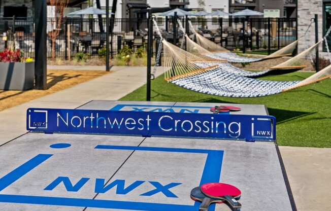 a playground with a northwest crossing sign and hammocks on the ground