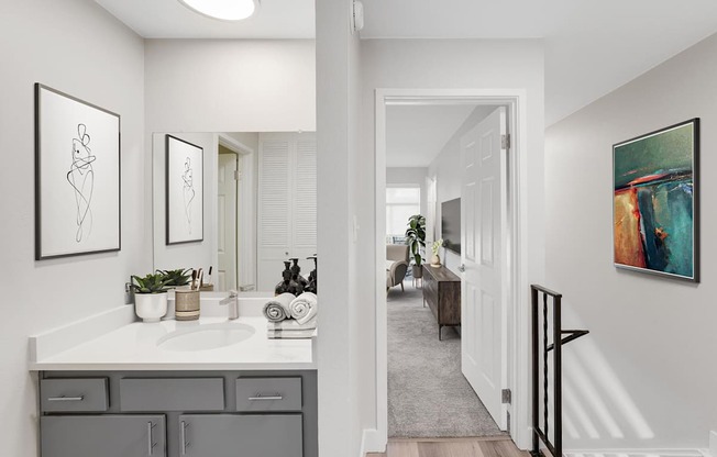 A bathroom with a white countertop and a white sink.