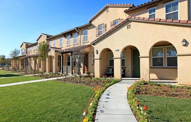 a sidewalk in front of a building with grass at The Vines at Riverpark, LLC, California, 93036