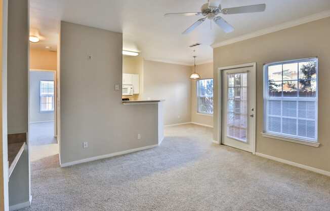 an empty living room with a ceiling fan