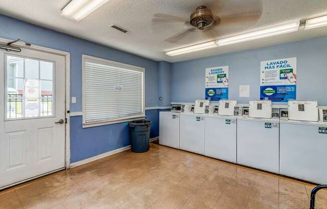 the laundry room is equipped with washers and dryers and the door is open