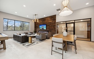 the living room and dining room in a modern home with a tv on the wall