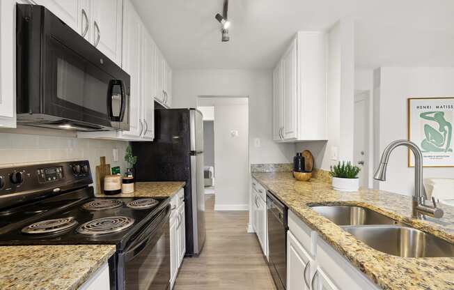 a kitchen with granite counter tops and black appliances