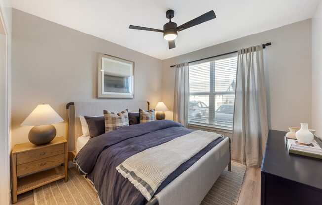 a bedroom with a bed and a ceiling fan