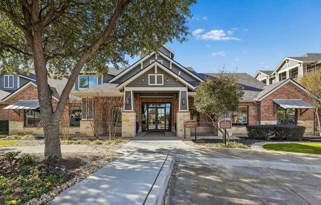 The image shows a building with a large tree in front of it.