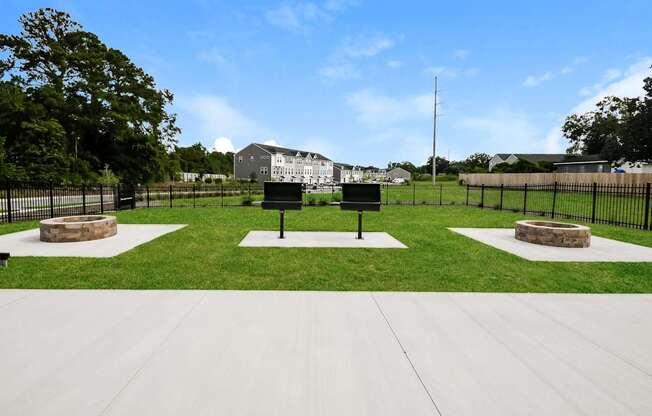 A park with a white sign and a black fence.