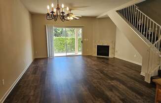 an empty living room with a fireplace and a chandelier