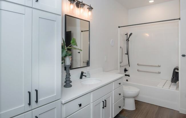 a bathroom with white cabinets and a white toilet and a sink and a bath tub at The Crossings at Windsong, Arizona