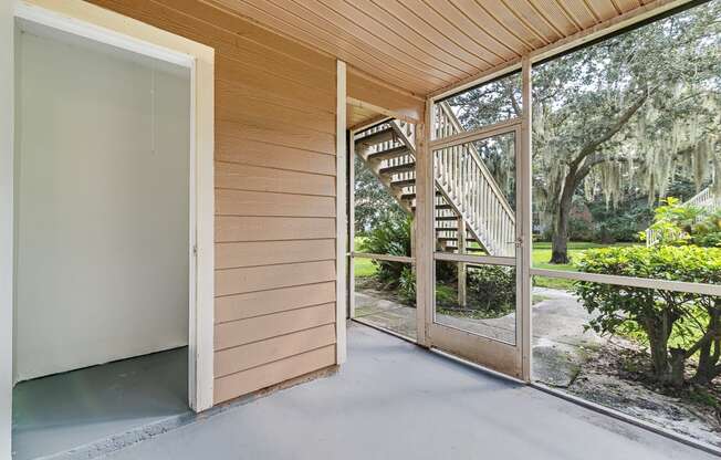 a sliding glass door opens to a porch with a view of a staircase