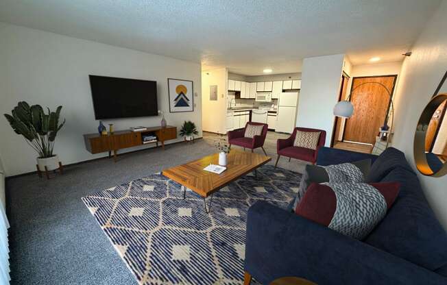 A living room with a dark blue couch and a wooden coffee table.