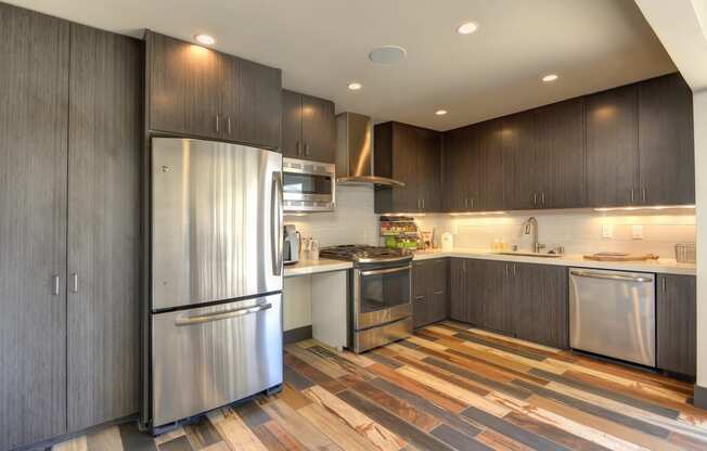 Leasing Office Kitchen with Hardwood Inspired Floors and Stainless Steel Refrigerator, Wood Inspired Floor, Wood Cupboards, Oven, Stove, Microwave