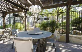 a patio with a table and chairs under a pergola