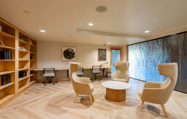 a living room with chairs and tables and a library