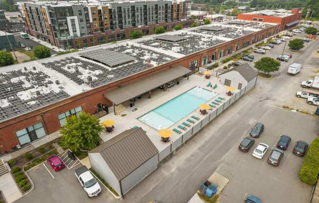 a large brick building with a pool and solar panels on top of it