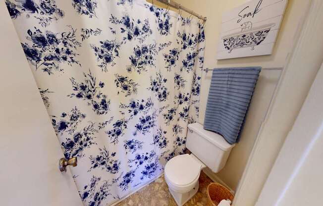 A blue and white floral shower curtain in a bathroom.