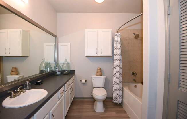A bathroom with a sink, toilet, and bathtub.