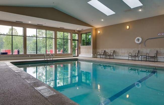 Indoor pool with high ceiling and lounge seating