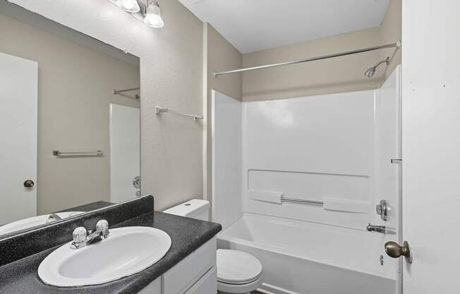 A white bathroom with a sink, toilet, and bathtub.
