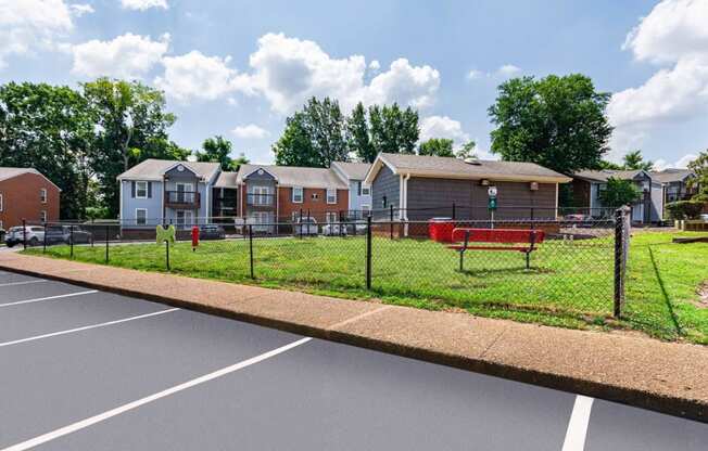 a fenced in park with houses in the background