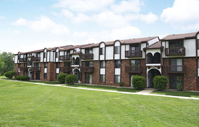 brick apartment building with a green lawn at Brookside Apartments in Springfield, MI