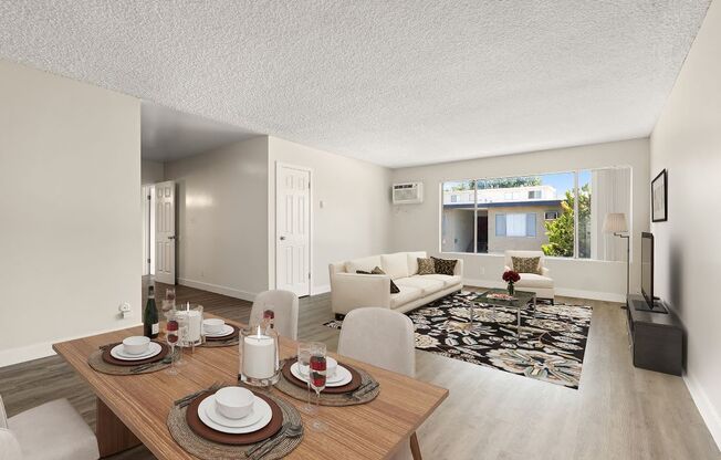 a living room and dining room with a table and chairs