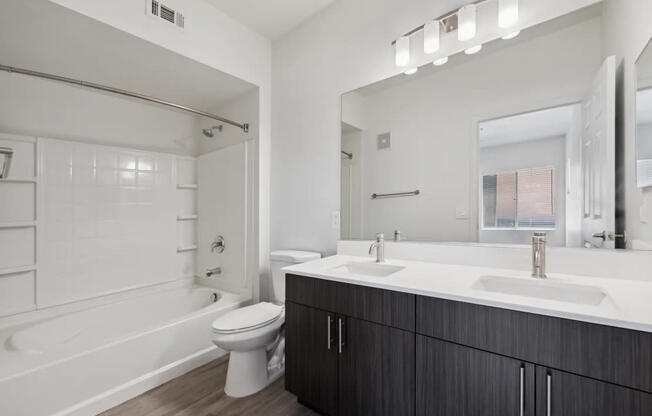 A white bathroom with a toilet, sink, and tub.