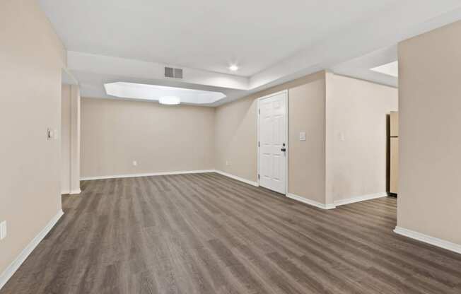 an empty living room with white walls and wood flooring